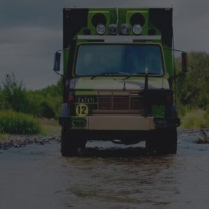 Four-wheel-drive vehicle travelling through a shallow creek